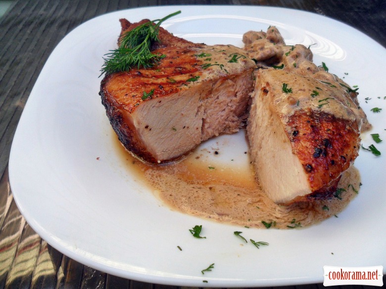 Steak from pork loin on the bone and cream sauce with demi glas.