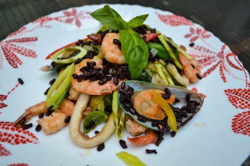 Seafood salad with rice Nerone, seasoned with pumpkin oil